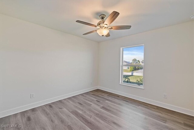 unfurnished room with ceiling fan, baseboards, and wood finished floors