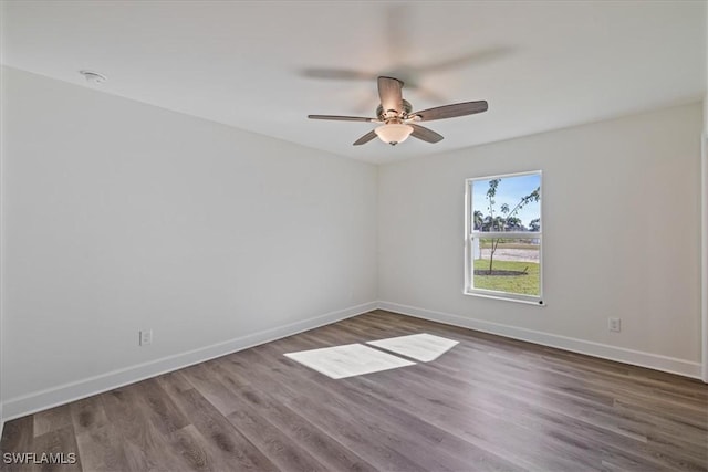 spare room featuring wood finished floors, baseboards, and ceiling fan