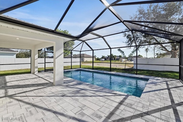 view of pool with glass enclosure and a patio area