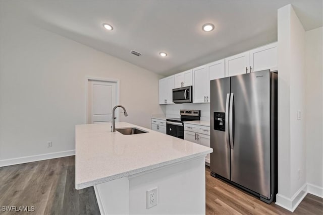 kitchen with a sink, vaulted ceiling, white cabinetry, and stainless steel appliances