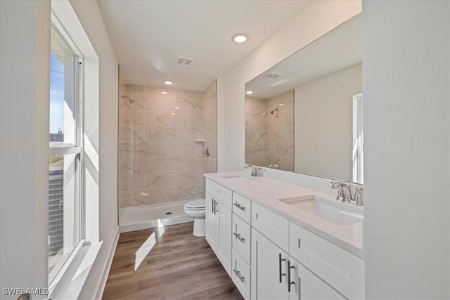 bathroom with a stall shower, visible vents, and a sink