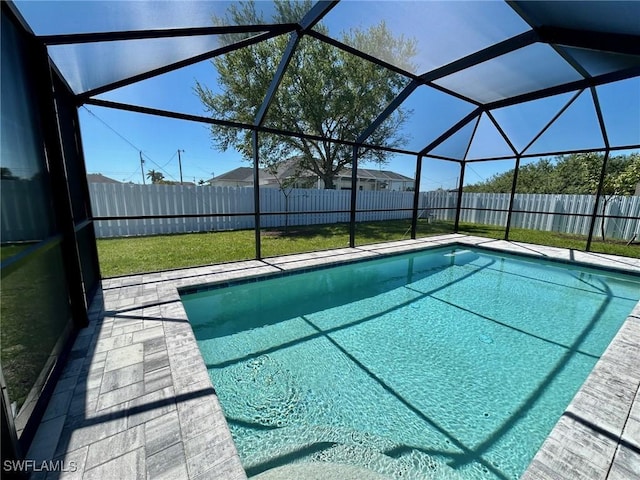 view of swimming pool with glass enclosure, a fenced backyard, and a fenced in pool