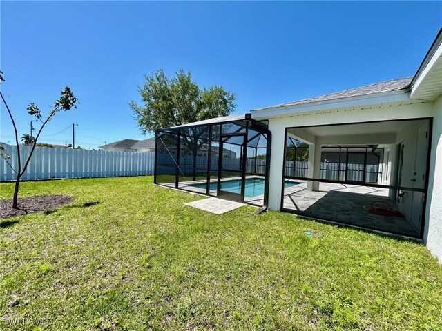 view of yard with glass enclosure, a patio, a fenced backyard, and a fenced in pool