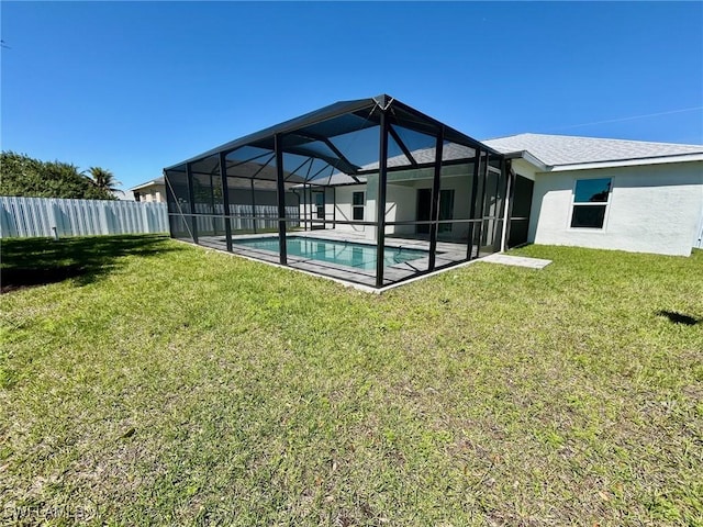 back of house featuring a yard, glass enclosure, stucco siding, and fence