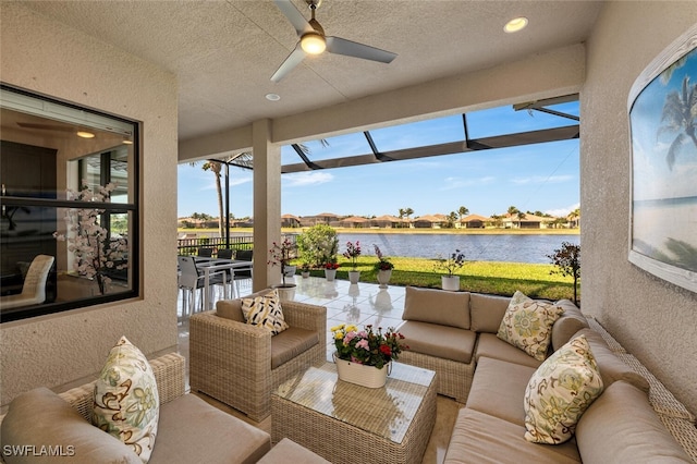 sunroom / solarium with ceiling fan, a wealth of natural light, and a water view