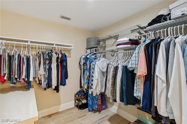 walk in closet with wood finished floors and visible vents