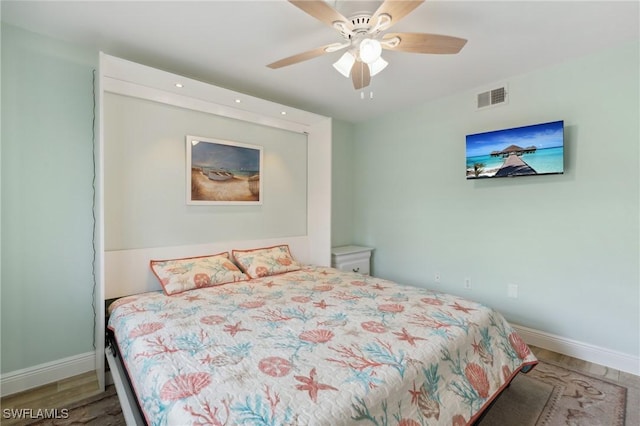 bedroom featuring ceiling fan, wood finished floors, visible vents, and baseboards