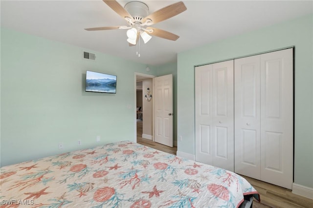 bedroom featuring a closet, visible vents, a ceiling fan, light wood-type flooring, and baseboards