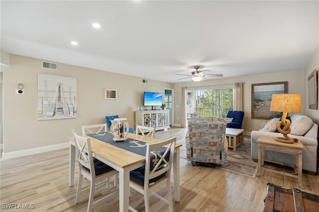 dining space with a ceiling fan, light wood-type flooring, visible vents, and baseboards