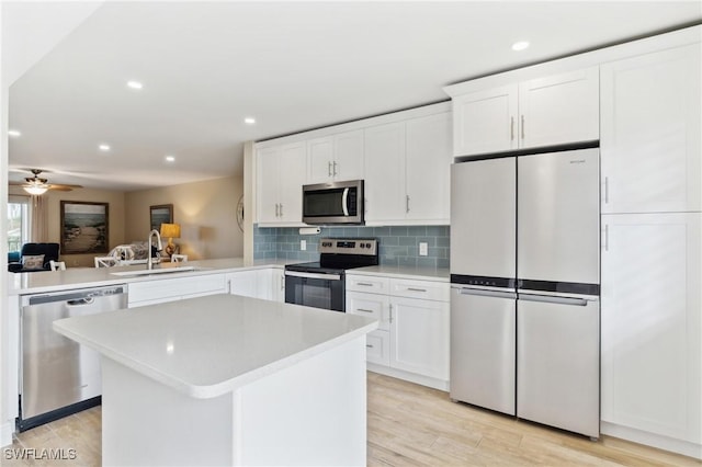 kitchen featuring decorative backsplash, appliances with stainless steel finishes, light countertops, and a sink