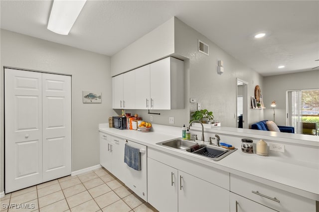 kitchen featuring white cabinetry, dishwasher, sink, and light tile patterned floors