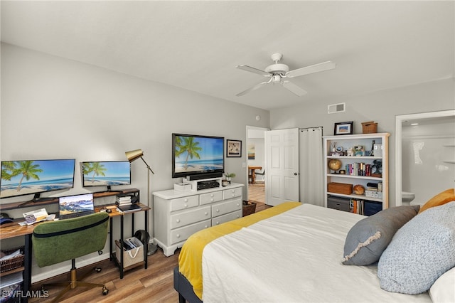 bedroom featuring ceiling fan, light hardwood / wood-style floors, and connected bathroom