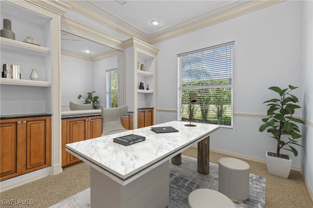 kitchen featuring built in shelves, crown molding, a kitchen bar, light carpet, and a kitchen island