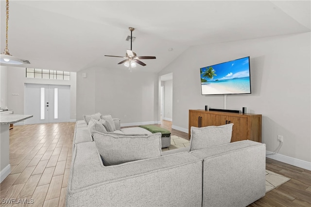 living room with ceiling fan, wood-type flooring, and vaulted ceiling