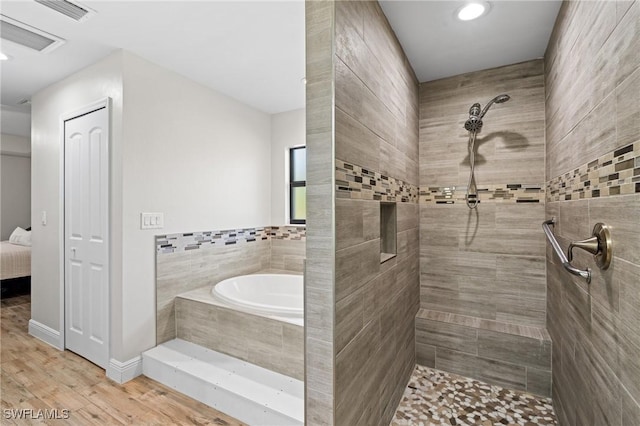 bathroom featuring hardwood / wood-style flooring and separate shower and tub