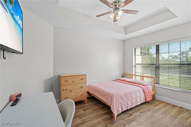 bedroom with ceiling fan and a tray ceiling