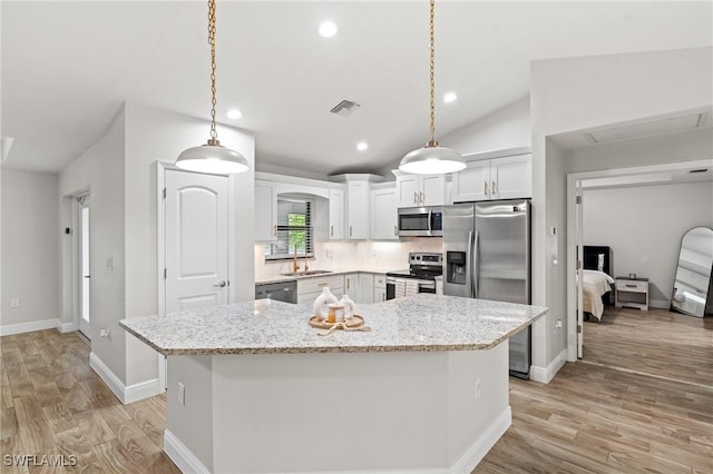 kitchen with pendant lighting, a center island, and appliances with stainless steel finishes