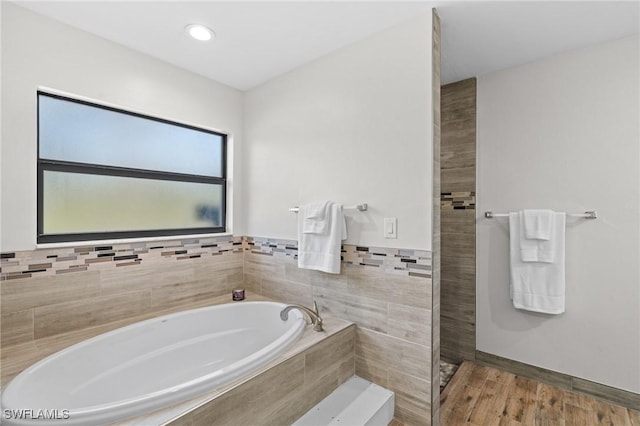 bathroom featuring hardwood / wood-style flooring and a bath