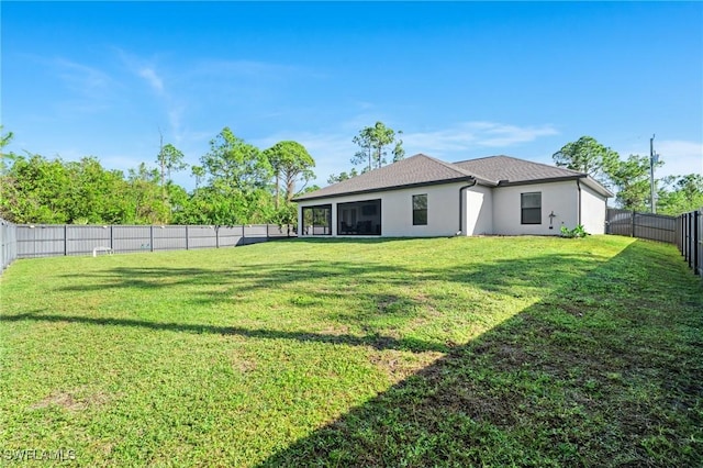 back of house featuring a sunroom and a yard