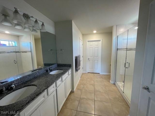 bathroom with tile patterned flooring, vanity, and a shower with shower door