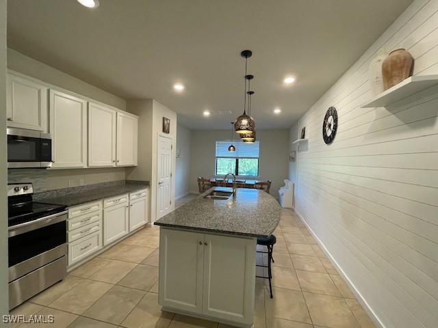 kitchen with a center island with sink, sink, white cabinetry, and stainless steel appliances