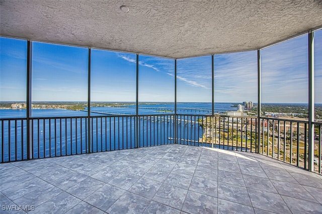 unfurnished sunroom featuring a water view