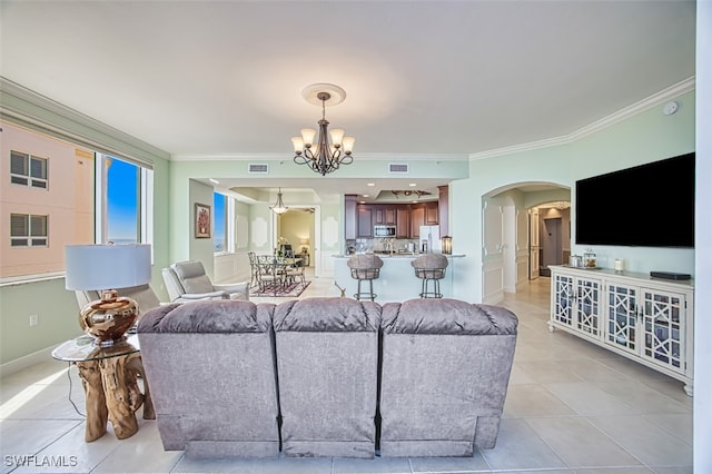 tiled living room featuring ornamental molding and an inviting chandelier