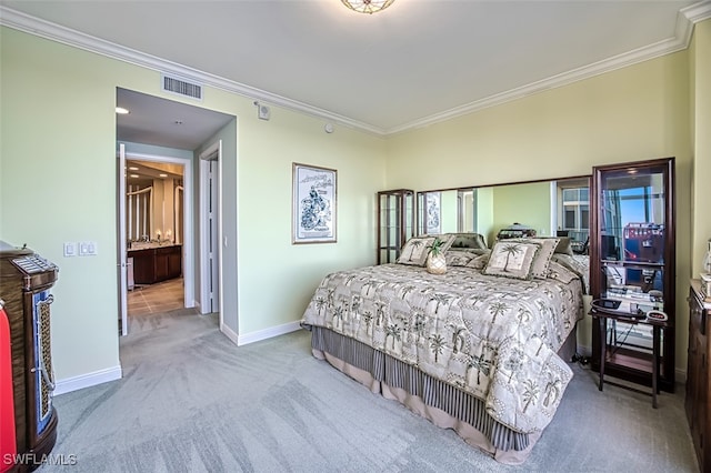 carpeted bedroom with ornamental molding and ensuite bath