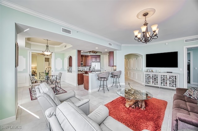 living room with a notable chandelier, light tile patterned flooring, and ornamental molding