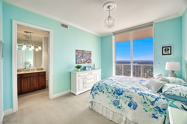 carpeted bedroom featuring ensuite bath, ornamental molding, access to outside, sink, and a notable chandelier