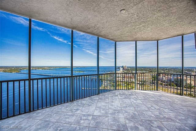 unfurnished sunroom with a water view