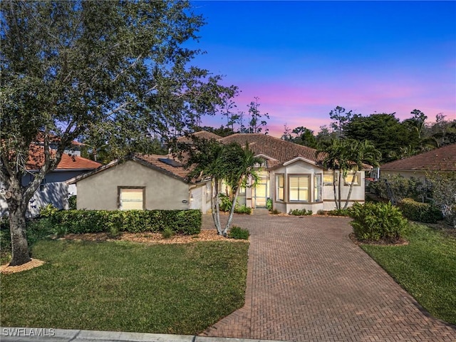 20838 Torre Del Lago St, Estero, FL 33928 - view of front of home with decorative driveway, stucco siding, a front yard, a tile roof, and a garage