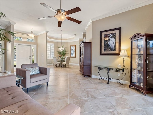 living room featuring ceiling fan, ornamental molding, light tile patterned floors, and a tray ceiling