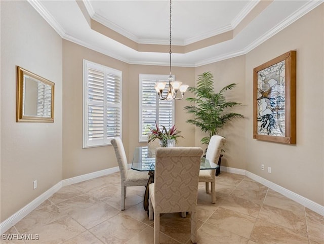 dining area with a notable chandelier, crown molding, and a tray ceiling