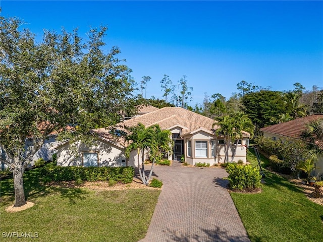 20838 Torre Del Lago St, Estero, FL 33928 - mediterranean / spanish-style house with decorative driveway, stucco siding, a front yard, a tile roof, and an attached garage