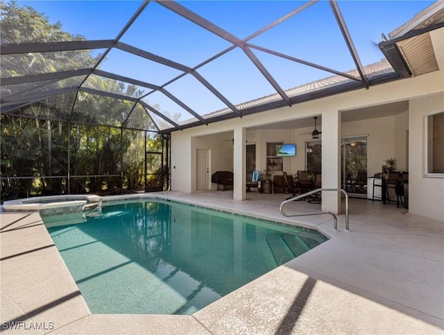 view of pool featuring ceiling fan, a patio area, an in ground hot tub, and glass enclosure