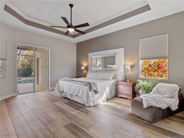 bedroom with access to outside, a raised ceiling, ceiling fan, and light hardwood / wood-style flooring