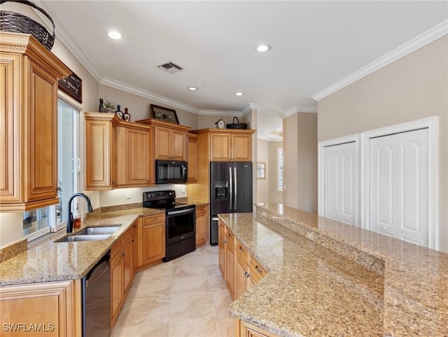 kitchen featuring light stone countertops, ornamental molding, sink, black appliances, and a center island