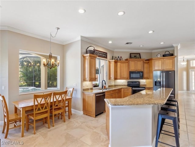 kitchen with crown molding, a chandelier, a center island, and black appliances