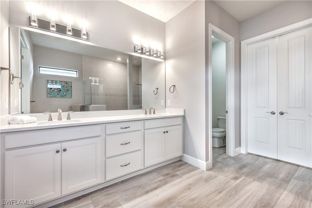 bathroom featuring vanity, hardwood / wood-style flooring, toilet, and walk in shower