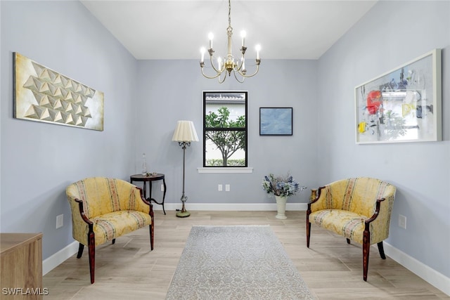 sitting room featuring a notable chandelier and light wood-type flooring