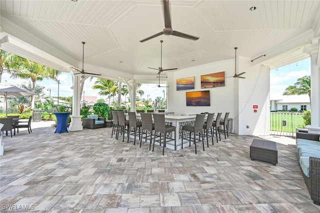 view of patio with a bar, an outdoor hangout area, and ceiling fan