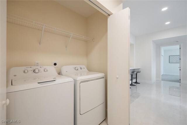 clothes washing area featuring independent washer and dryer and light tile patterned floors