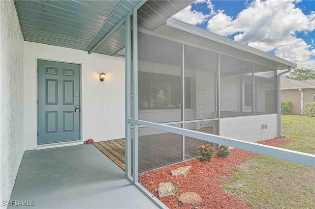 entrance to property featuring a lawn