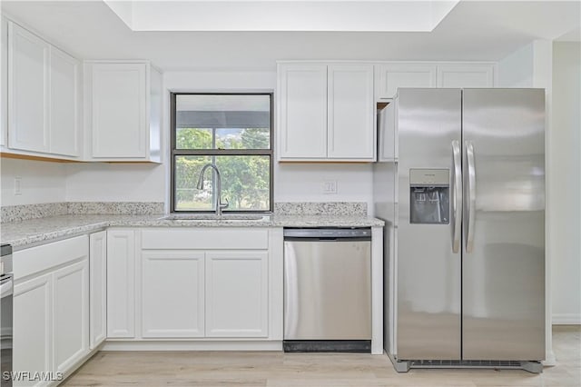 kitchen featuring light stone countertops, sink, white cabinets, and stainless steel appliances