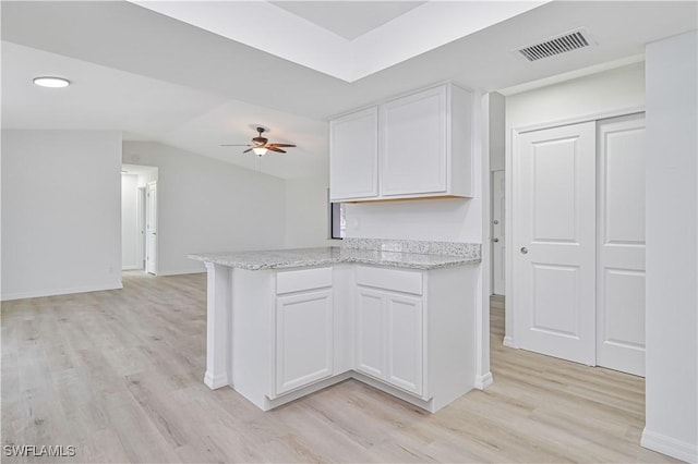 kitchen featuring light hardwood / wood-style flooring, ceiling fan, white cabinetry, and kitchen peninsula