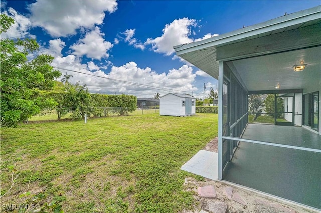 view of yard featuring a storage unit and a sunroom