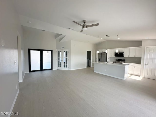 kitchen with french doors, an island with sink, decorative light fixtures, white cabinets, and appliances with stainless steel finishes