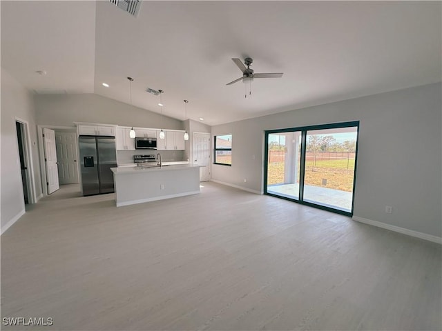 unfurnished living room featuring ceiling fan, sink, vaulted ceiling, and light wood-type flooring