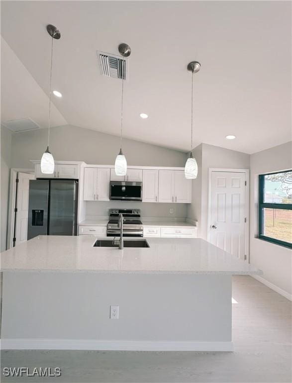 kitchen featuring sink, stainless steel appliances, light stone counters, pendant lighting, and white cabinets